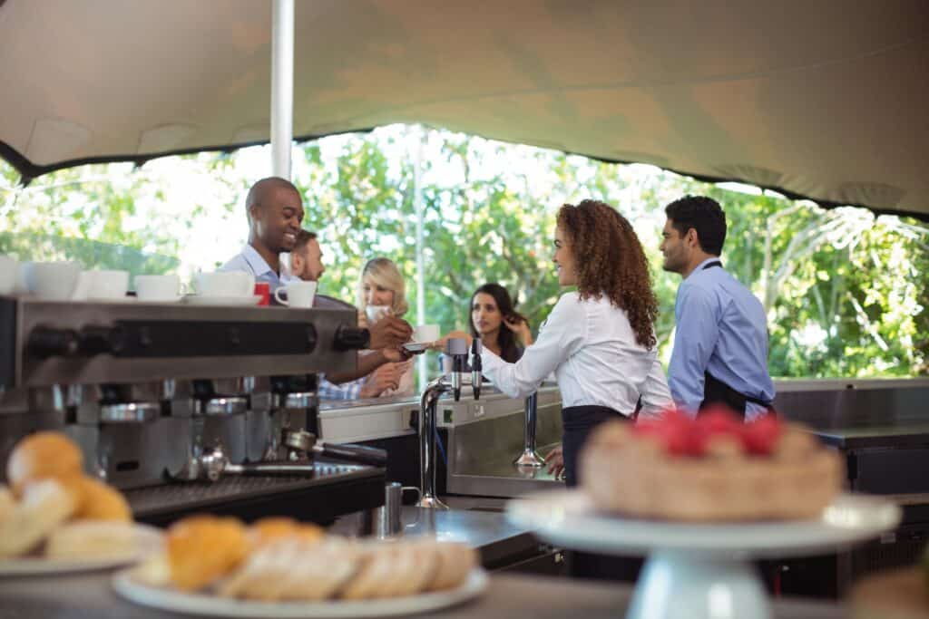 waitress-serving-coffee-to-customer-at-counter-2025-04-05-02-16-37-utc